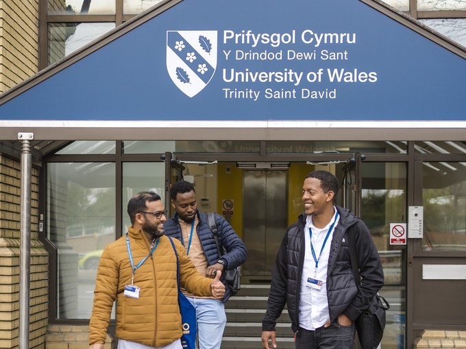Three students walking out of UWN Cardiff 