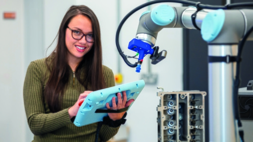 Student smiling and operating machinery 