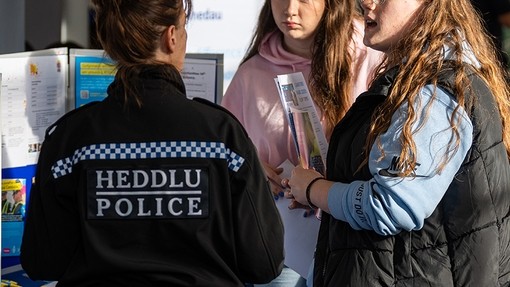Police officer in discussion with two students