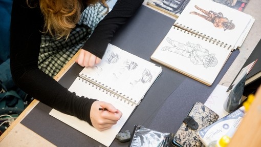 Illustration student drawing in a sketchbook