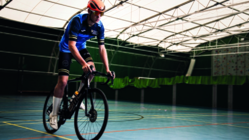 Student on bike in the Carmarthen sports hall
