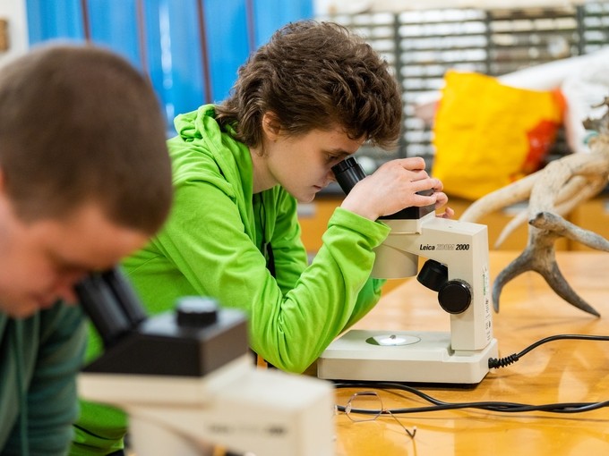 Students looking through microscopes 