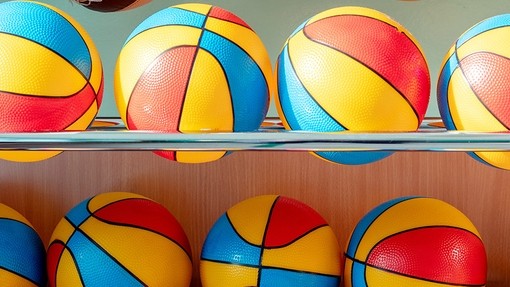 Large balls for school sports made of plastic in primary colours.